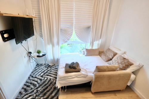 a bedroom with a bed and a chair and a window at 7min BKK airport - free pick up - malls nearby in Bangkok
