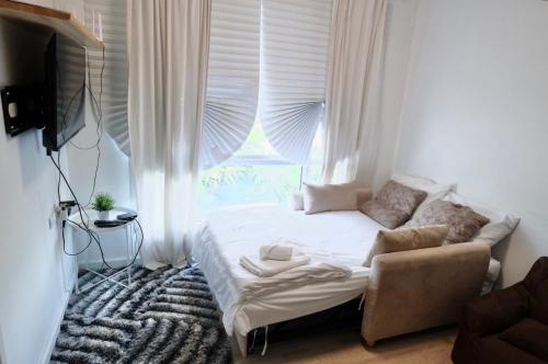 a small bedroom with a bed and a window at 7min BKK airport - free pick up - malls nearby in Bangkok