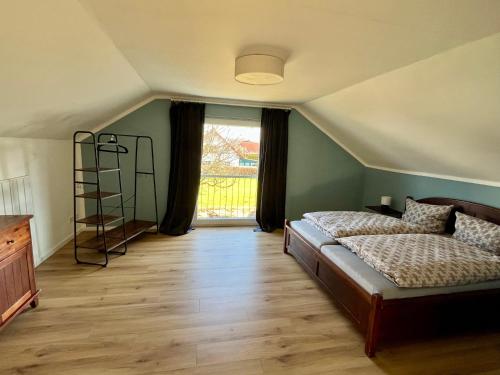 a bedroom with a bed and a large window at Gemütliche Dachgeschosswohnung auf dem Land in Blomberg