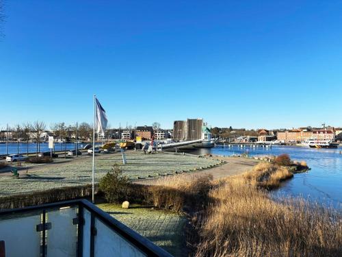 a walkway next to a river with a bridge at Penthouse Kapitänsbrücke in Kappeln