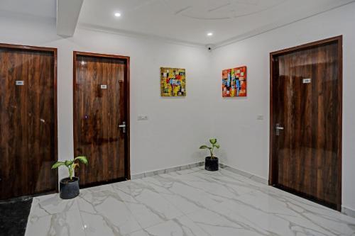 a room with two doors and two potted plants at Collection O Kanchan Heritage in Gurgaon