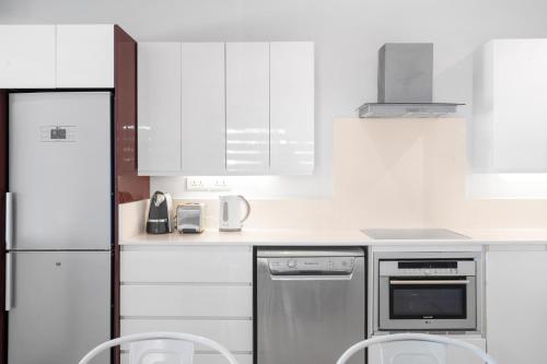 a white kitchen with white appliances and white cabinets at Kanope Bay - Holiday Beachfront Apartments in Pointe aux Biches