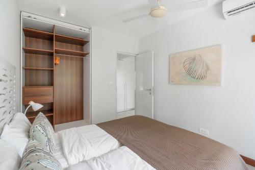 a white bedroom with a bed and a closet at Kanope Bay - Holiday Beachfront Apartments in Pointe aux Biches