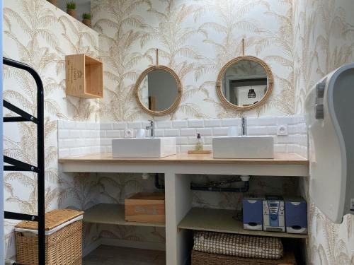 une salle de bain avec deux lavabos et deux miroirs dans l'établissement Maison familiale avec piscine privée à Saint-Vincent-sur-Jard - FR-1-336-136, à Saint-Vincent-sur-Jard
