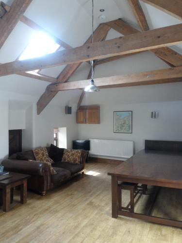 a living room with a couch and a table at Plasglasgwm in Betws-y-coed