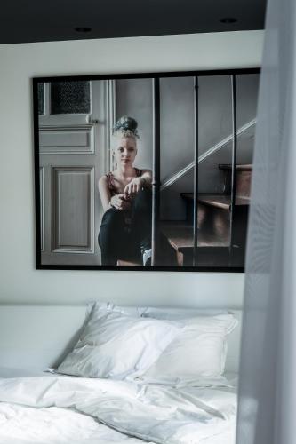 a picture of a girl sitting on a bed at Le Général Hôtel in Paris