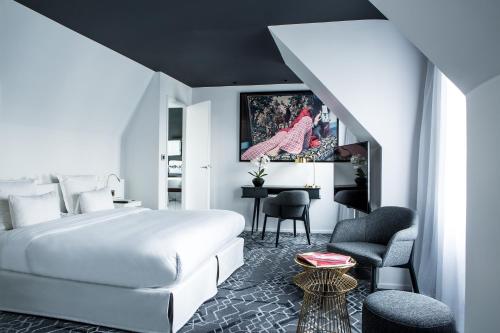 a hotel room with a white bed and a desk at Le Général Hôtel in Paris