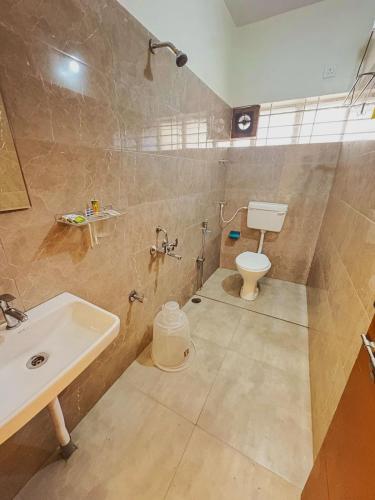a bathroom with a sink and a toilet at Sai Grand Villa Hotel Near Bangalore Airport in Bengaluru