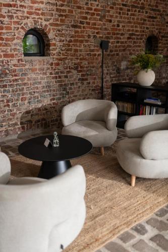a room with chairs and a table and a brick wall at Hotel Lohauser Hof in Düsseldorf
