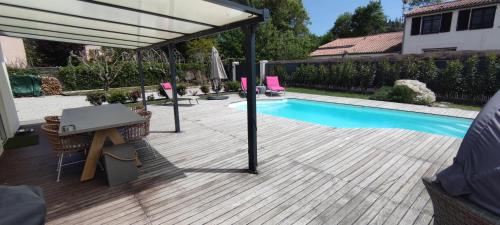 - une terrasse avec une table et un parasol à côté de la piscine dans l'établissement Charmant studio climatisé avec parking, terrasse et piscine, à Villeneuve-Loubet