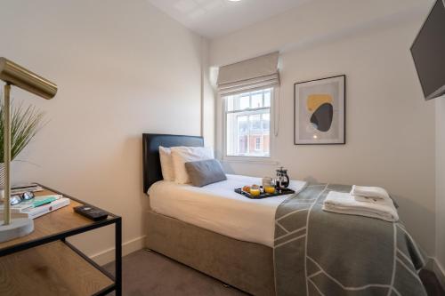 een slaapkamer met een bed met daarop een dienblad met fruit bij Wellington House by Celador Apartments in Reading