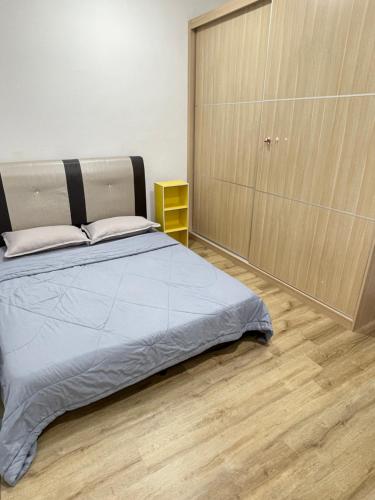 a bedroom with a bed and a wooden floor at Hann's Residence - Anna 温馨公寓式的住宅 in Sibu