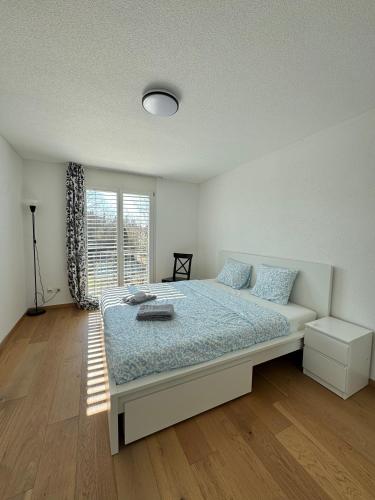 una camera da letto con un letto e una finestra di VK - HL - Zürich Airport - Luxury - Homestay - Härdlenstrasse - Kloten a Kloten