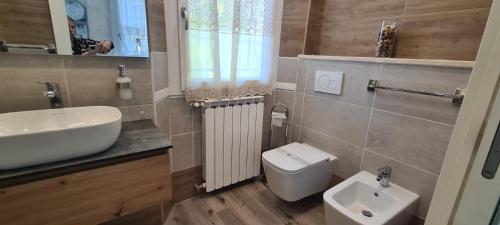 a bathroom with a white sink and a toilet at B&B Le Palme in Appiano Gentile