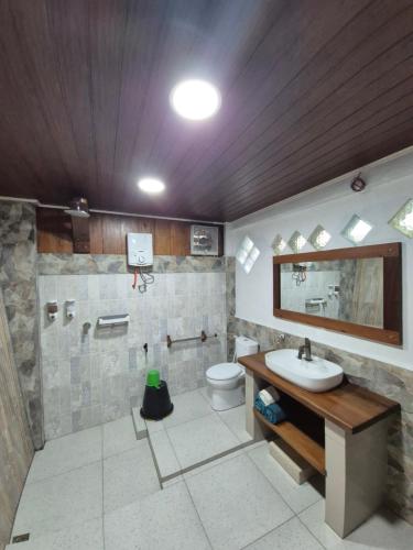 a bathroom with a sink and a toilet at Sam's Bungalows And Treks in Bukit Lawang