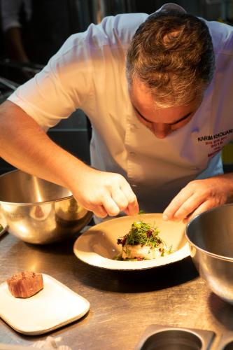 a chef preparing a plate of food on a table at Stayso The House Hotel in Istanbul
