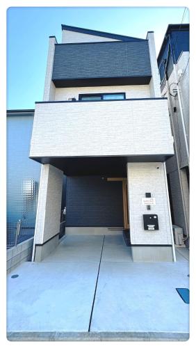 a building with a parking lot in front of it at Hao Bros Home Gemini A in Tokyo