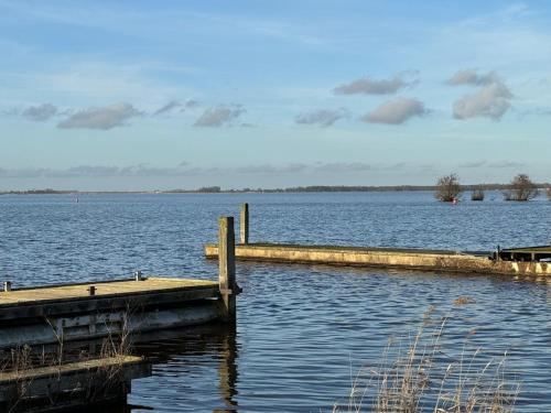 a dock on a large body of water at Houseboat mét sloep in Midlaren