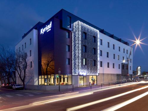 a lit up building on a street at night at Kyriad Troyes Centre in Troyes