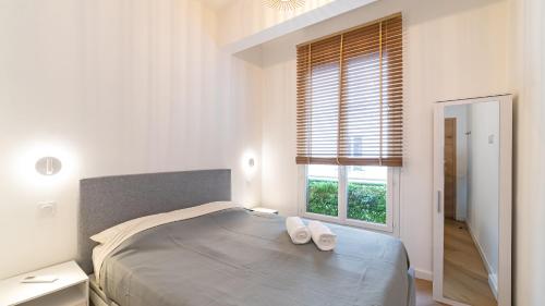 - une chambre dotée d'un lit avec deux chaussures blanches dans l'établissement B G Cocon Meyerbeer - Grimaldi Promenade des Angla, à Nice