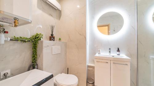 une salle de bain avec toilettes, lavabo et miroir dans l'établissement B G Cocon Meyerbeer - Grimaldi Promenade des Angla, à Nice