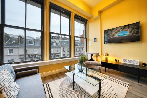 a living room with a lot of windows at Union Court Mezzanine - B9 - Building has no lift and stairs to all apartments in Glasgow