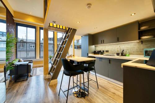 a kitchen with a table and chairs in a room at Union Court Mezzanine - B9 - Building has no lift and stairs to all apartments in Glasgow