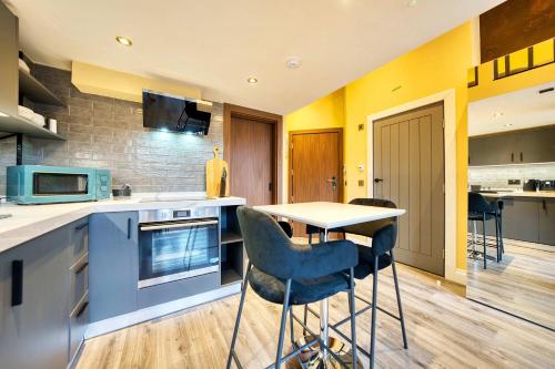 a kitchen with a table and chairs in it at Union Court Mezzanine - B9 - Building has no lift and stairs to all apartments in Glasgow