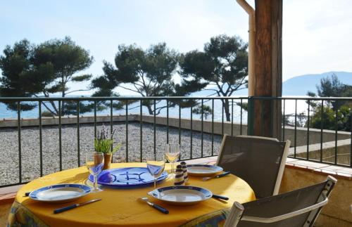 une table avec un chiffon de table jaune sur un balcon dans l'établissement Bel appartement 4 pers plage de Gigaro 114, à La Croix-Valmer