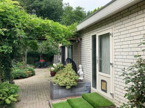 a garden with a statue on the side of a house at Natuurbungalow Het Koolmeesje in Putten