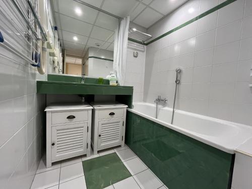 une salle de bain avec un lavabo, une baignoire et un miroir dans l'établissement CAP HERMES, Magnifique Vue mer pour ce studio 33m2, à Fréjus