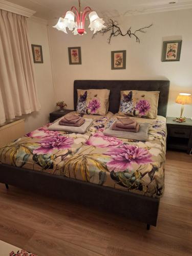 a bedroom with a large bed with flowers on it at Natuurbungalow Het Koolmeesje in Putten