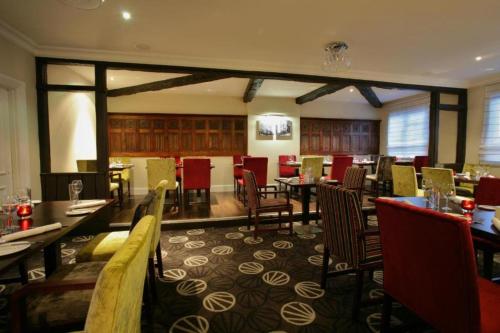 a dining room with tables and chairs in a restaurant at Exeter Rougemont Station Experience By Palette Resorts in Exeter