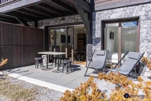 d'une terrasse avec des chaises, une table et une table. dans l'établissement Apartment near Mont D'auron, à Auron
