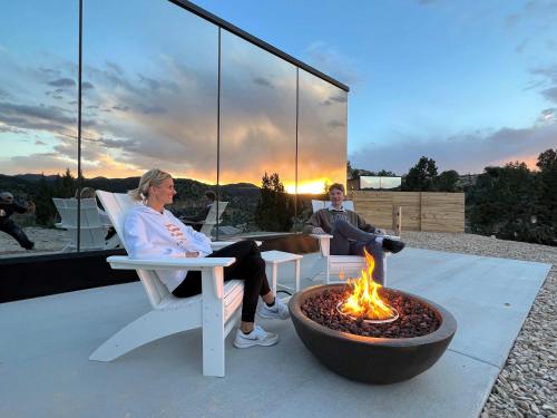 two women sitting in chairs next to a fire pit at Mirror House Zion at East Zion Resort in Orderville
