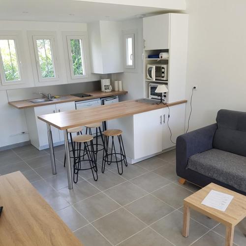 une cuisine et un salon avec une table et un canapé dans l'établissement Bel appartement 2 pièces rénové proche plages rez de jardin, à Cavalaire-sur-Mer