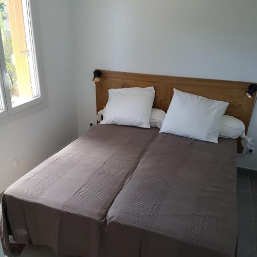 - un grand lit avec 2 oreillers blancs dans l'établissement Bel appartement 2 pièces rénové proche plages rez de jardin, à Cavalaire-sur-Mer