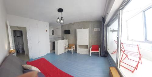 a living room with a blue floor and a kitchen at Studio VUE MER in Saint-Jean-de-Monts