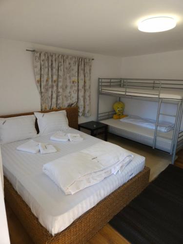 a bedroom with two bunk beds with white sheets at Undeva la Mosie in Podu Dîmboviţei