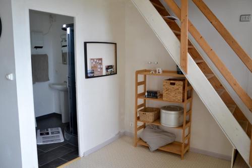 baño con escalera y habitación con estante en Petit Paris en Kergrist