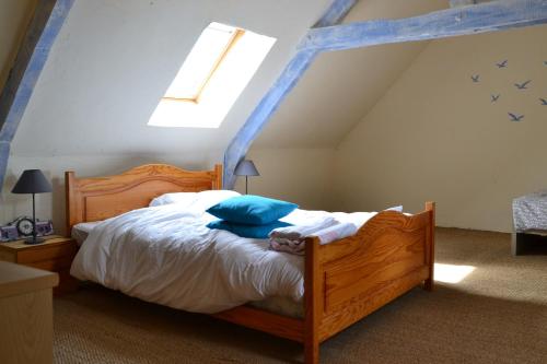 KergristにあるPetit Parisのベッドルーム1室(木製ベッド1台、青い枕付)