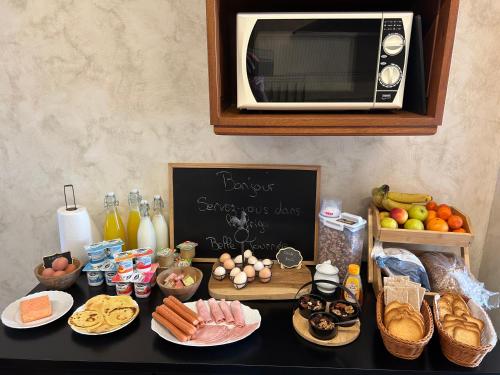 a table with some food and a microwave on top at La ferme du paradis in Merris