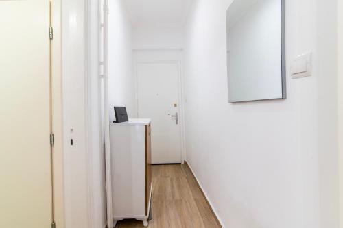 a hallway with two white doors and a picture on the wall at EXQUISITE BRAND - New Modern Apt in Central Athens - 270m to Metro & Attractions in Athens