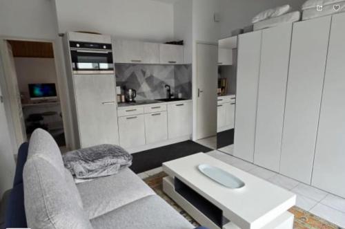 une grande cuisine blanche avec un canapé et une table dans l'établissement La Bisquine, au Bois-Plage-en-Ré