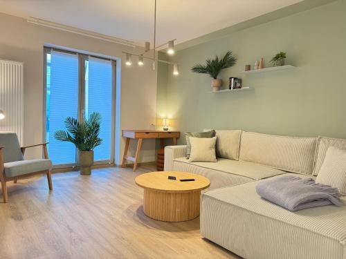 a living room with a couch and a table at LIGHTPLACE • Design • Boxspring • Balkon • 2 Smart TV •Innenstadt in Braunschweig