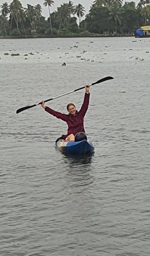 a woman paddling a kayak on a body of water at ABRU'S Holidays International Travelers in Alleppey