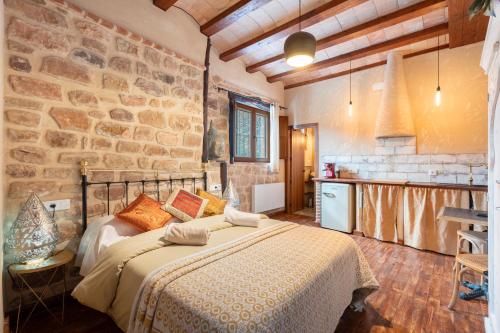 Un dormitorio con una cama y una pared de piedra. en La Casuca, en Olba