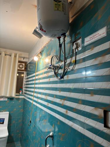 a bathroom with a blue and white tiled wall at Hills Royal Residency in Jālāpahār