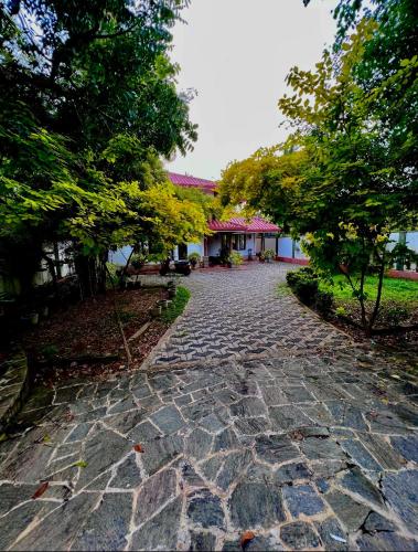 a cobblestone path in front of a house at Gemlita Villa in Uswetakeiyawa in Bopitiya