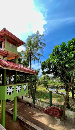a green building with a sign in front of it at Gemlita Villa in Uswetakeiyawa in Bopitiya